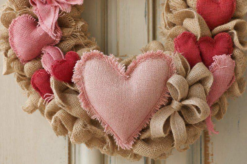 Finished burlap wreath with a raw-edge fabric heart accent wired at the bottom — AI-generated image
