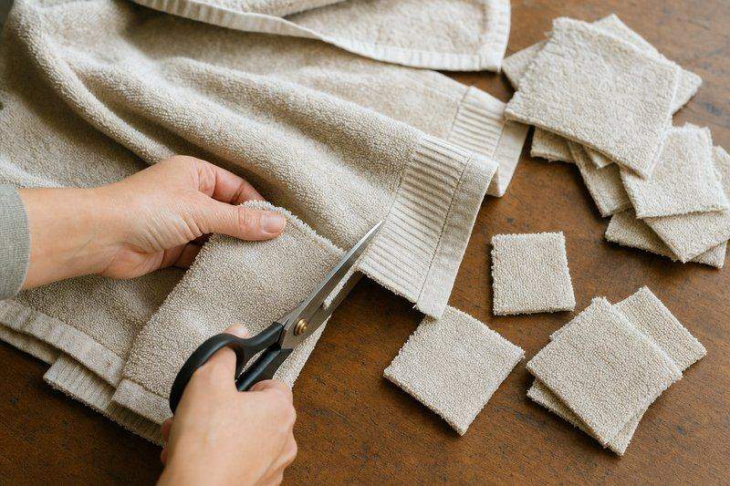 An old towel being cut into small squares for cleaning rags on a craft table — AI-generated image